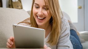 Foto von lächelnder Teilnehmerin mit Tablet