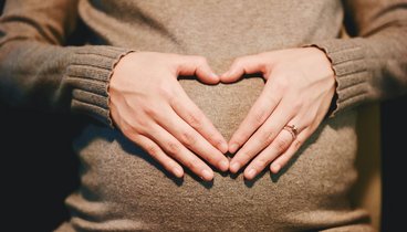 Symbolbild Hände in Herzform vor dem Bauch einer Schwangeren